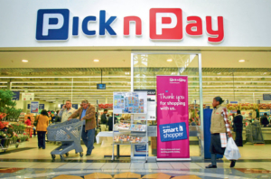 Customers exit a Pick n Pay Stores Ltd. supermarket in Johannesburg, South Africa, on Monday, July 25, 2011. Pick n Pay Stores Ltd., South Africa's second-biggest grocer, this month said it plans to fire 3,137 workers, or 8.6 percent of its workforce, to trim labor costs. Photographer: Nadine Hutton/Bloomberg